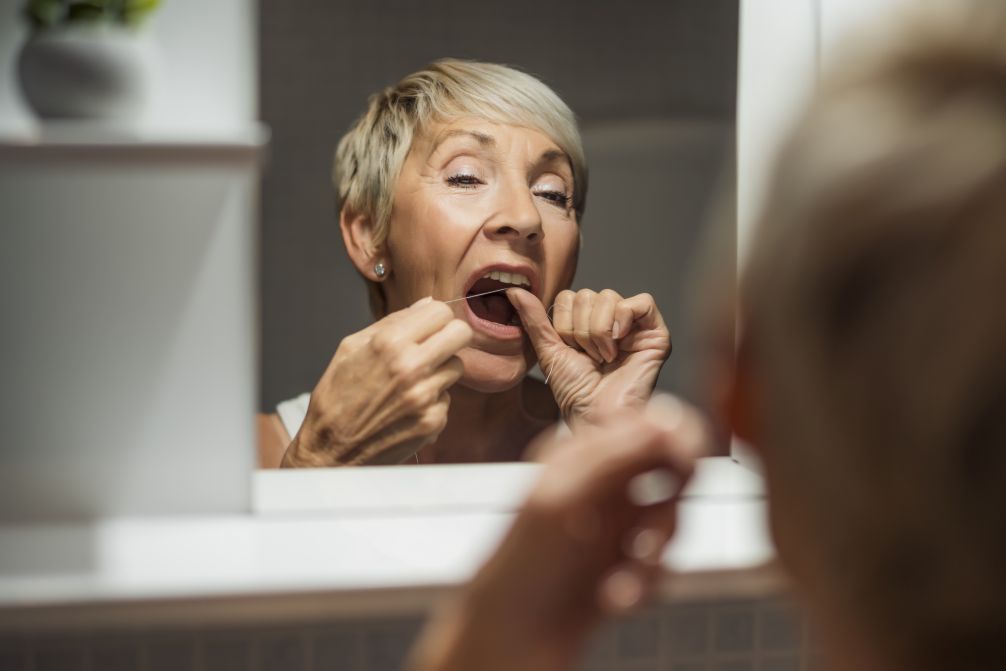 A woman flossing her teeth